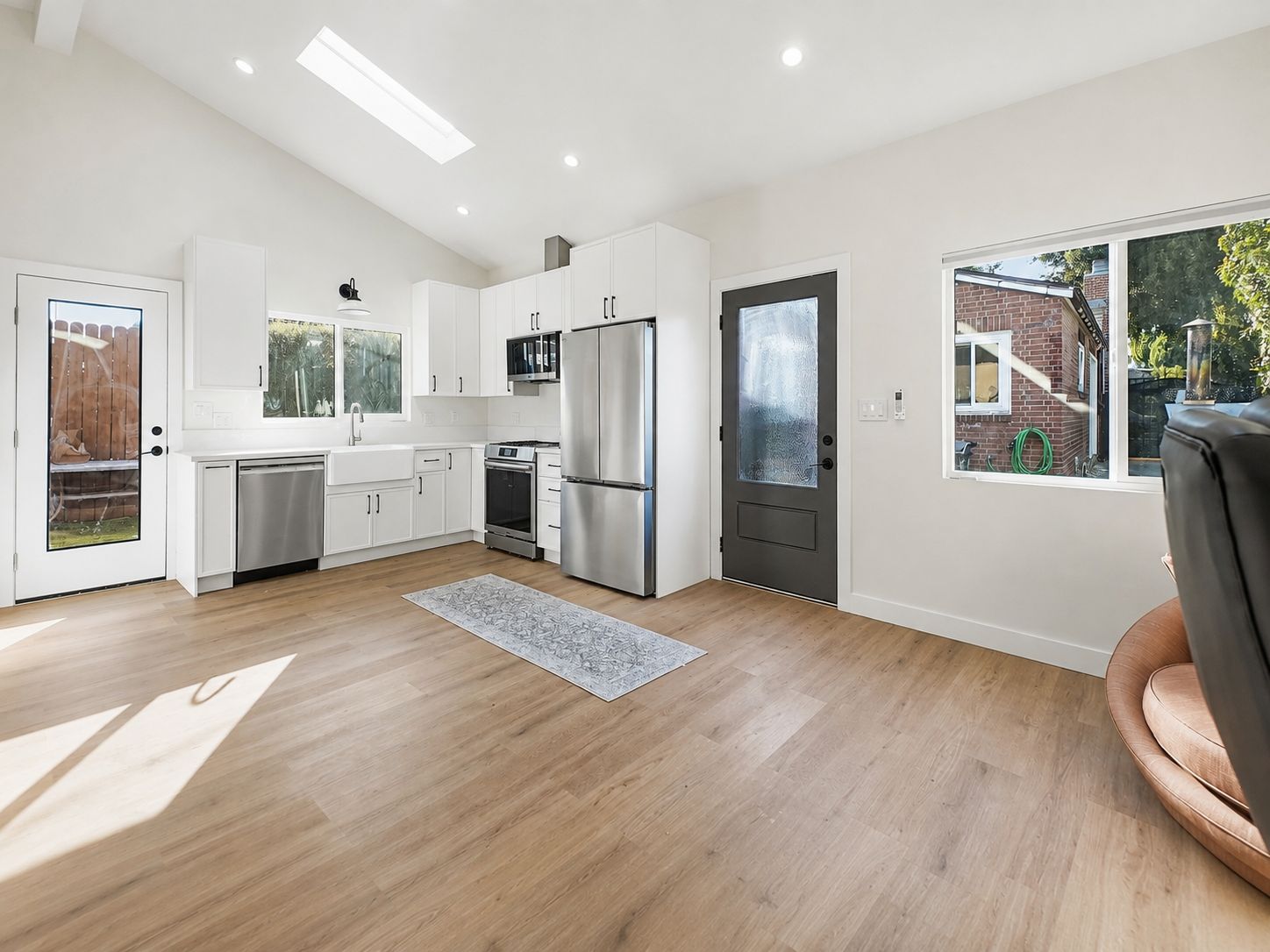 Open kitchen and living space with vaulted ceiling and skylight