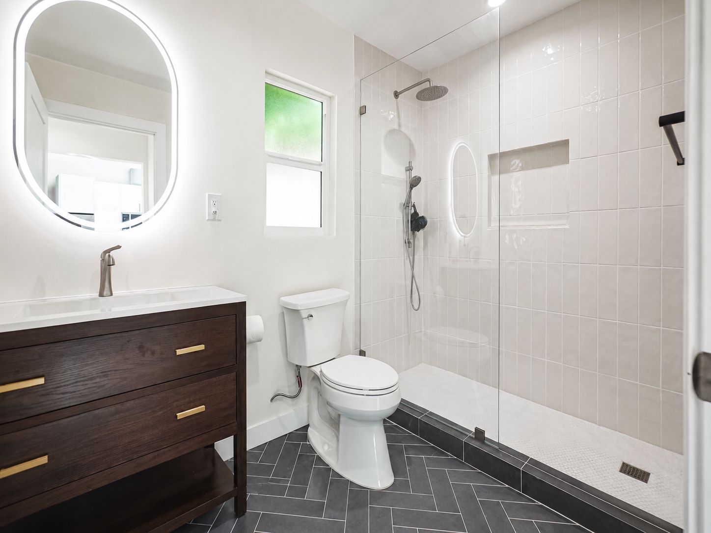 Bathroom with glass shower enclosure and dark wood vanity