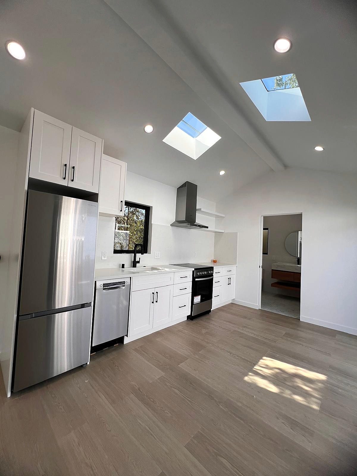 Kitchen and living area with skylights and view toward the bathroom
