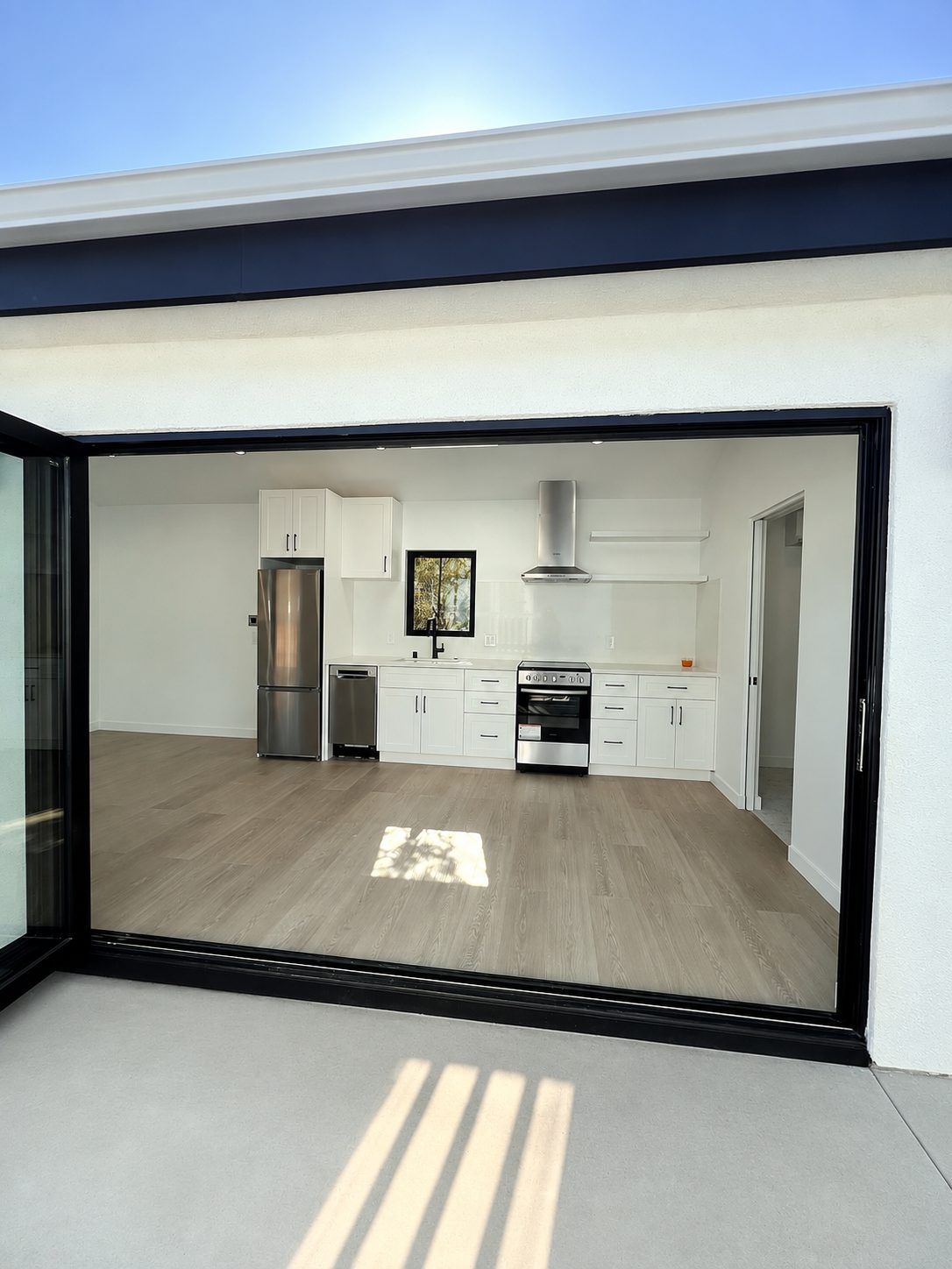 View into the finished kitchen through the open trifold door