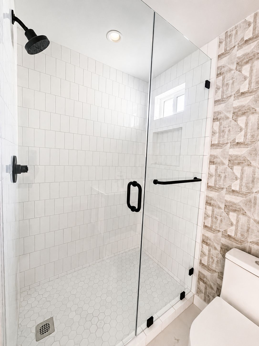 Finished bathroom shower with subway tile and black fixtures
