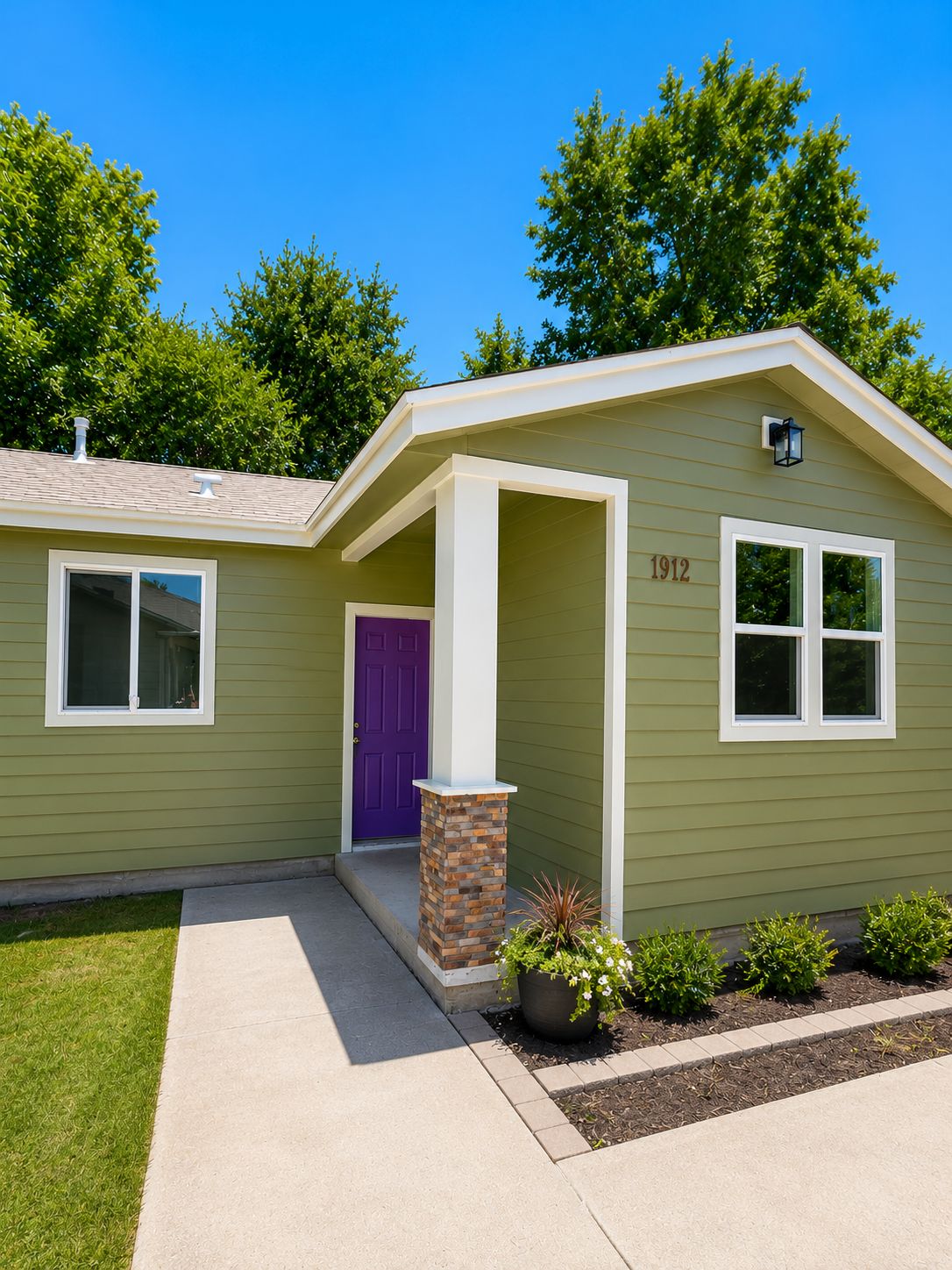Finished ADU exterior with green siding and purple front door