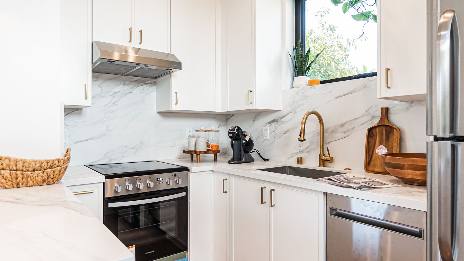 Kitchen counter detail with marble backsplash and gold fixtures