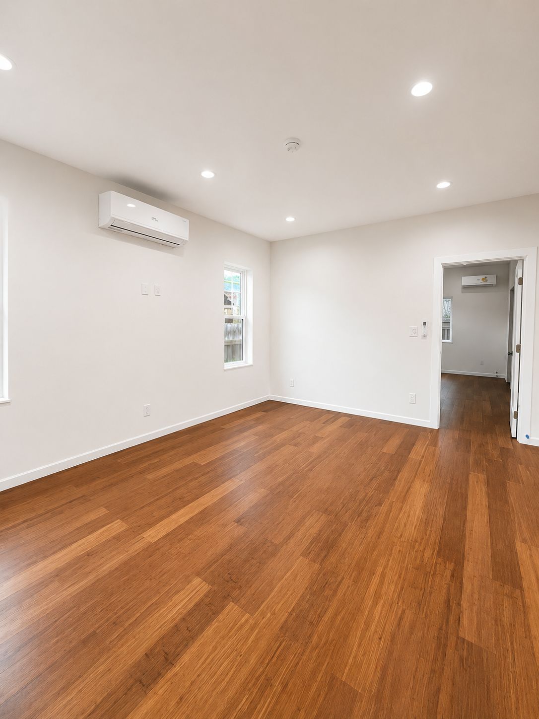 Living area with wide-plank flooring and mini-split unit