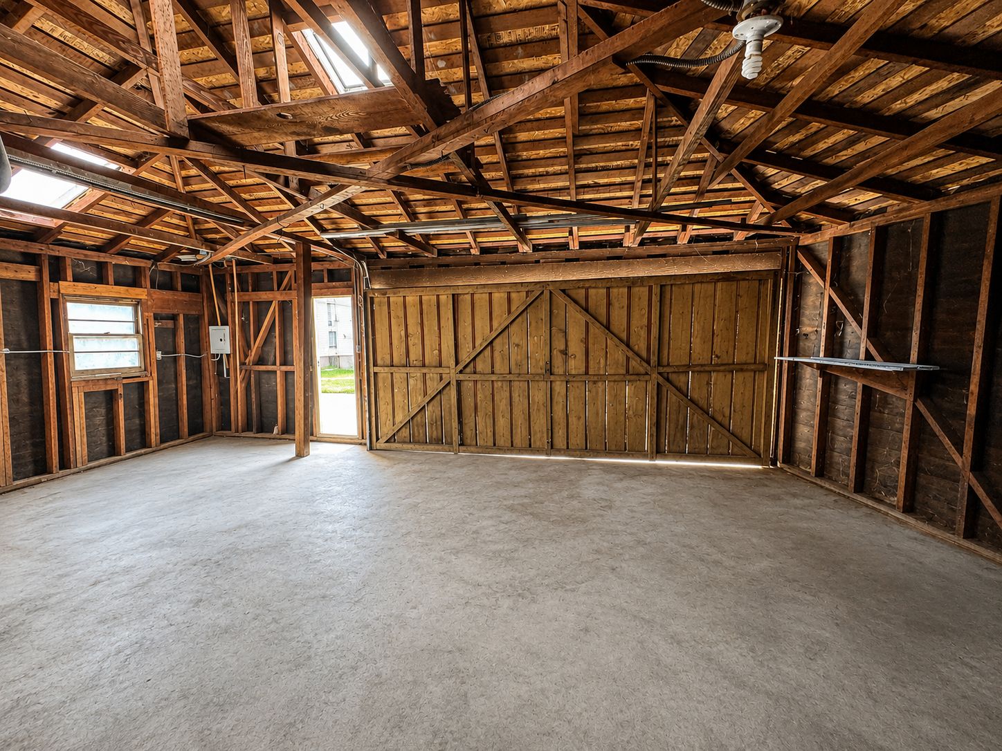 Original garage interior with framing and barn doors