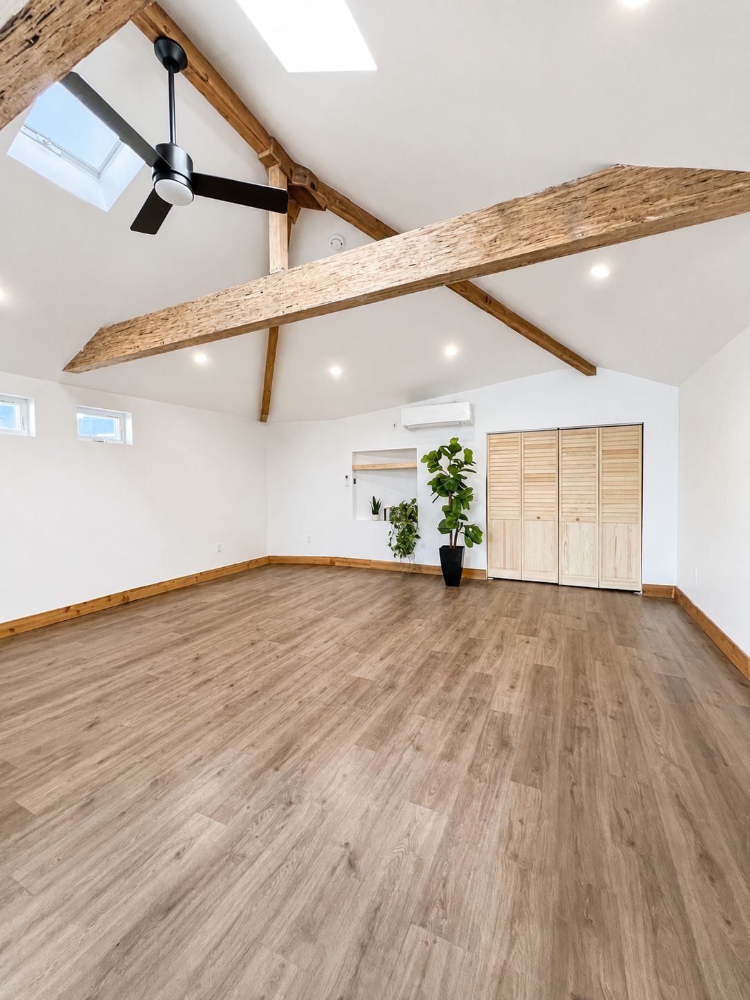 Finished living area with exposed wood beams and skylights